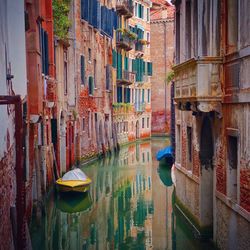 Boats in canal along buildings