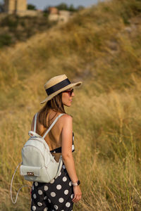 Woman wearing hat standing on field