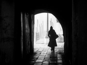 Rear view of woman walking in corridor of building