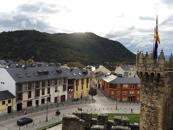 Buildings in town against cloudy sky