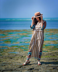 Rear view of woman standing at beach