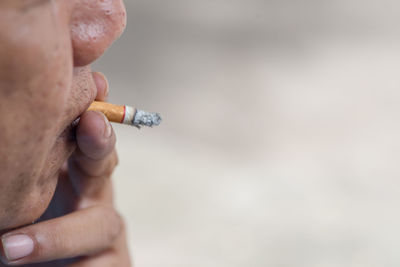 Cropped image of man smoking cigarette