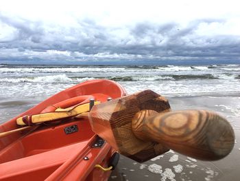 Close-up of motorcycle on beach against sky