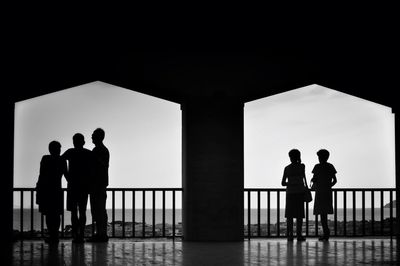 Silhouette people with arms outstretched in background