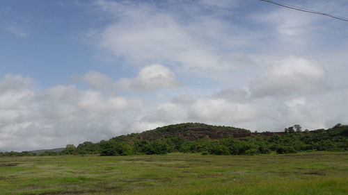 Countryside landscape against cloudy sky