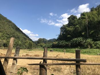 Wooden fence on field against sky