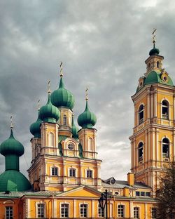 View of buildings in city against cloudy sky