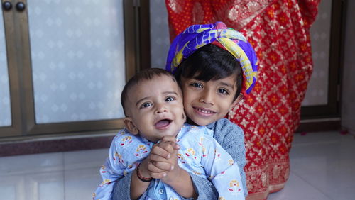 Portrait of cute baby girl sitting on sofa at home