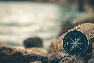 Compass of tourists on stone at riverside.