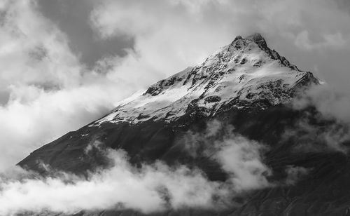 Low angle view of snowcapped mountains against sky