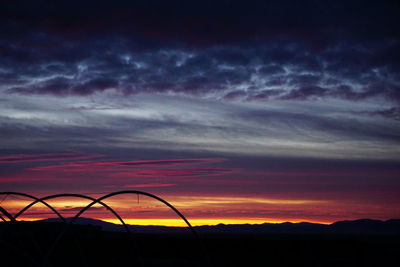 Low angle view of silhouette landscape against dramatic sky