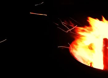 Close-up of illuminated fire against sky at night