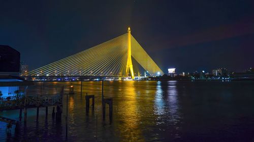 Illuminated bridge over river at night,nonthaburi bridge,bangkok,thailand