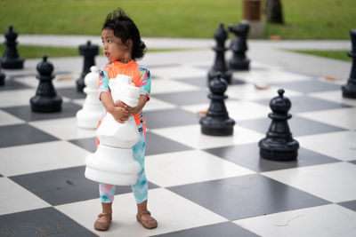 Full length of girl playing on chess board
