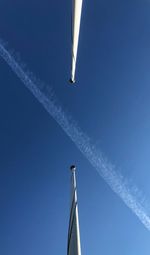 Low angle view of airplane flying against clear blue sky