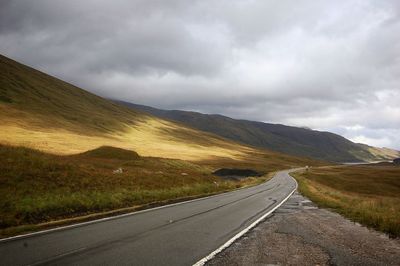 Road by mountain against sky