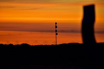 Silhouette tower against sky during sunset