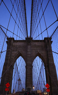 Low angle view of suspension bridge against blue sky