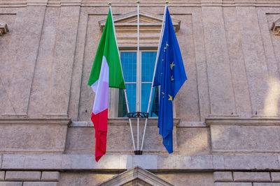 Low angle view of flags against blue wall