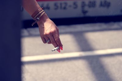 Close-up of hand holding cigarette