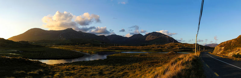 Panoramic view of road by mountains against sky