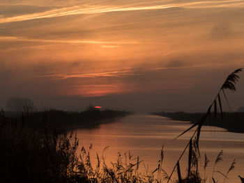 Scenic view of lake against sky during sunset