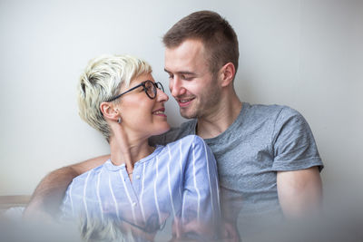 Close-up of romantic couple sitting by wall at home