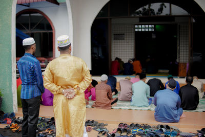 Rear view of people standing in temple