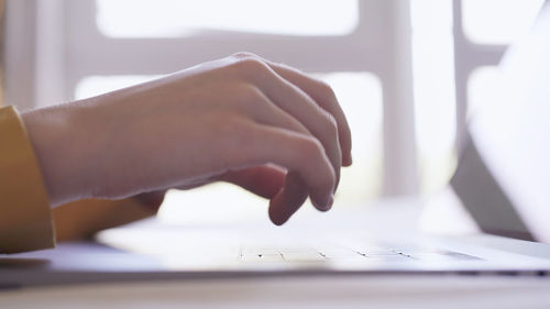 Cropped hands of man using laptop on table