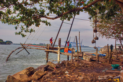 Scenic view of sea and fishermen against sky in south india 