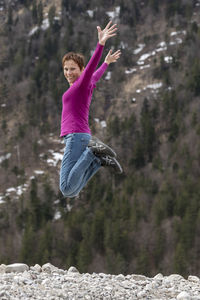 Portrait of woman jumping on land