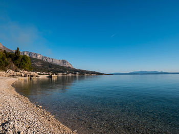 Scenic view of beach against blue sky