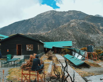 Rear view of man sitting against mountain