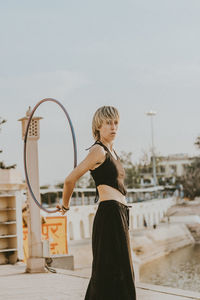 Side view of woman standing against sky