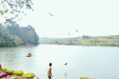 Man surfing in lake against clear sky