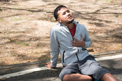 Man with chest pain sitting on road