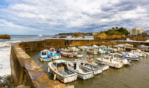 Boats moored on beach against sky