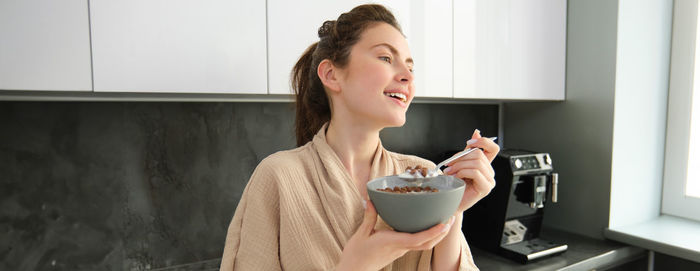 Portrait of young woman using mobile phone at home