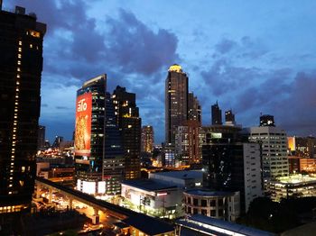 Illuminated buildings in city against sky at night