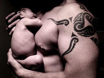 Midsection of man making face against black background