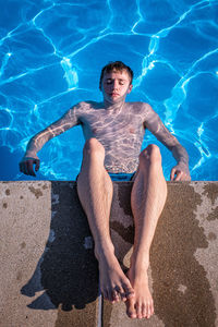 High angle view of teenage boys relaxing in swimming pool