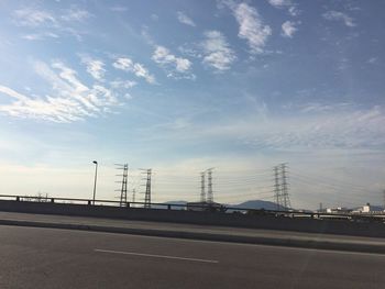 Electricity pylon against cloudy sky