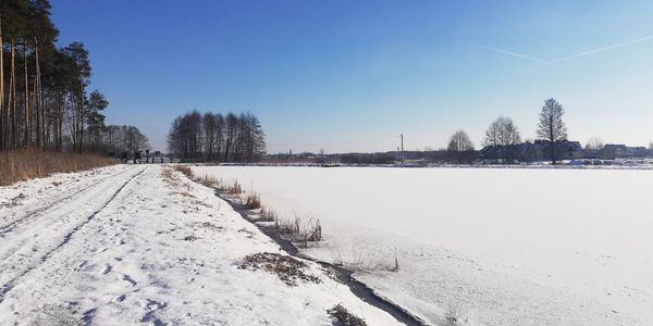 Scenic view of snow covered field against sky