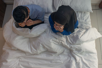 High angle view of people relaxing on bed at home