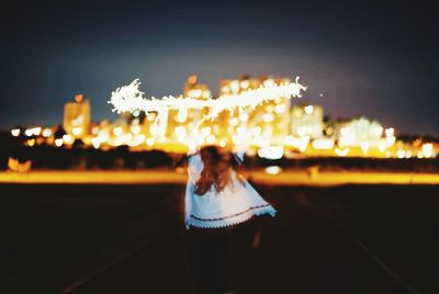 Rear view of woman at night