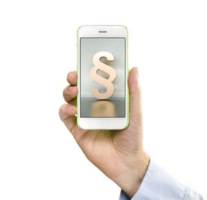 Close-up of hand holding smart phone over white background