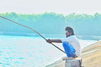 Side view of man fishing in lake