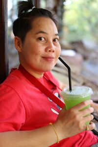 Portrait of mid adult woman drinking juice