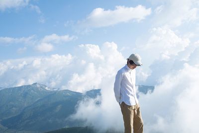 Man standing on mountain against sky