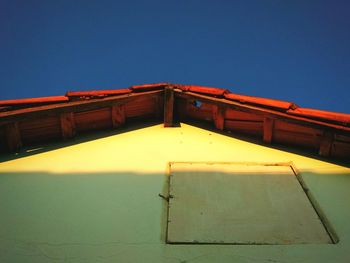 Low angle view of house against clear blue sky